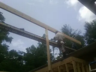 Carpenter setting a ridge beam over a new addition frame — Ice Dam Removal by Roofing Brothers in Avilla