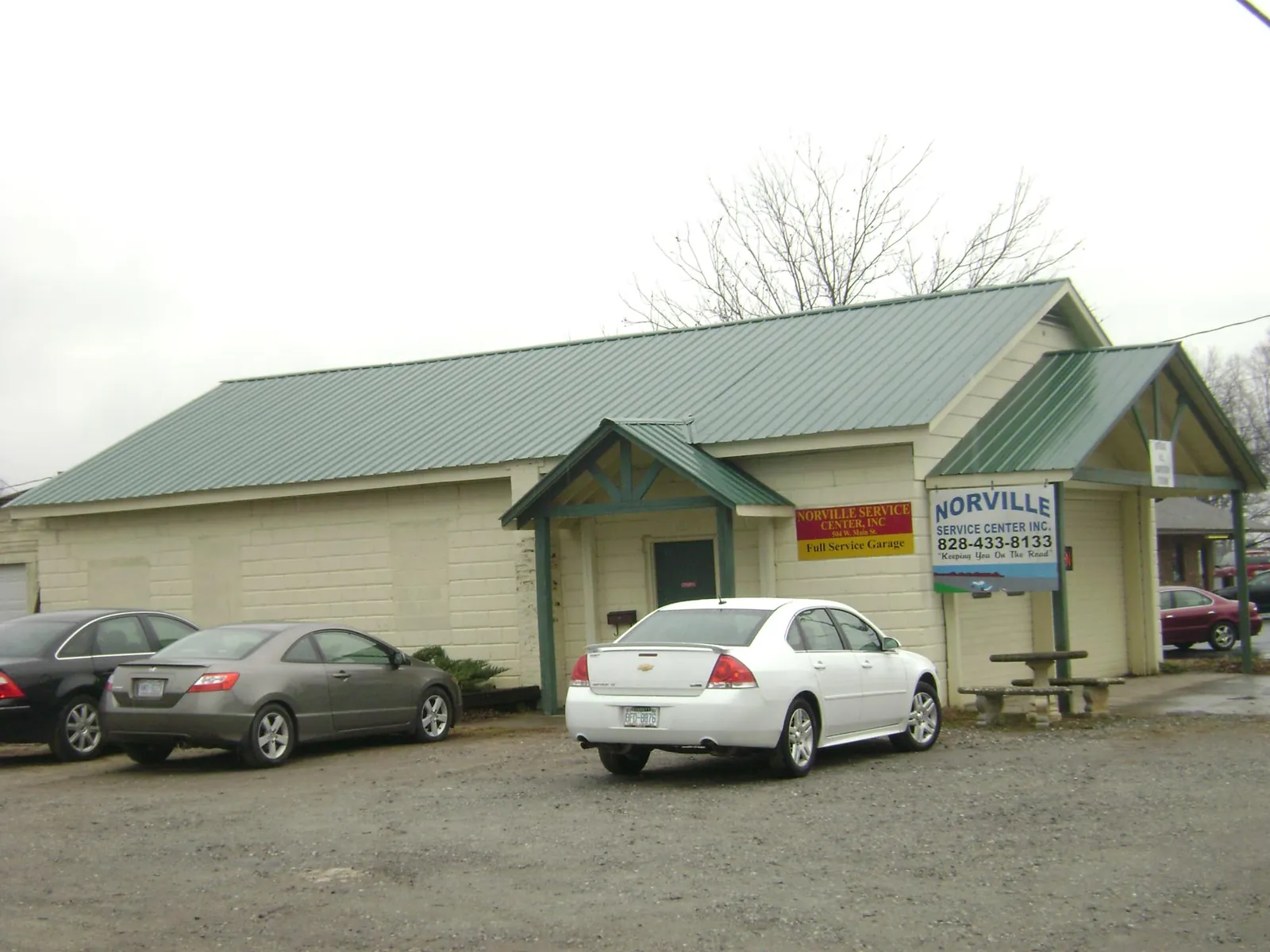 Green metal roof on a service garage with a covered entry in Avilla