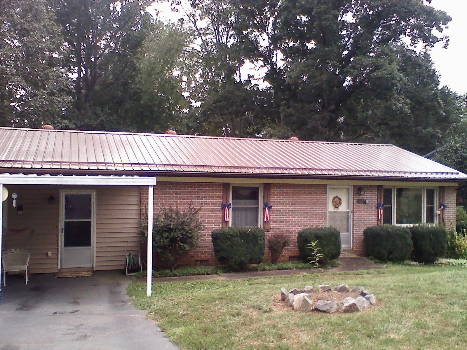 Bronze metal roof and carport on a brick ranch home — Roof Repair work by our crew in Avilla